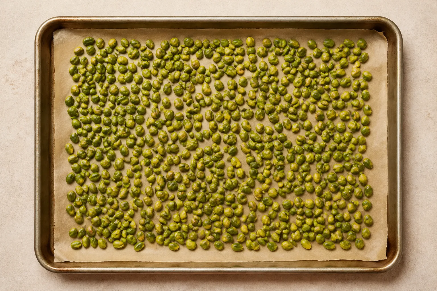 Peeled green pistachios on a baking sheet ready to toast