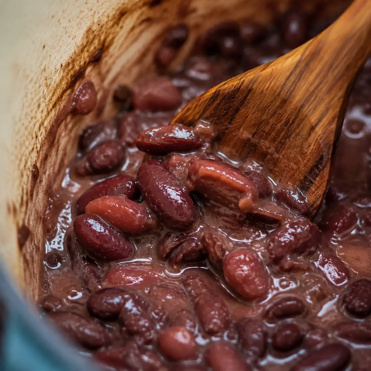 Mashing red beans against the pot for creamy red beans and rice