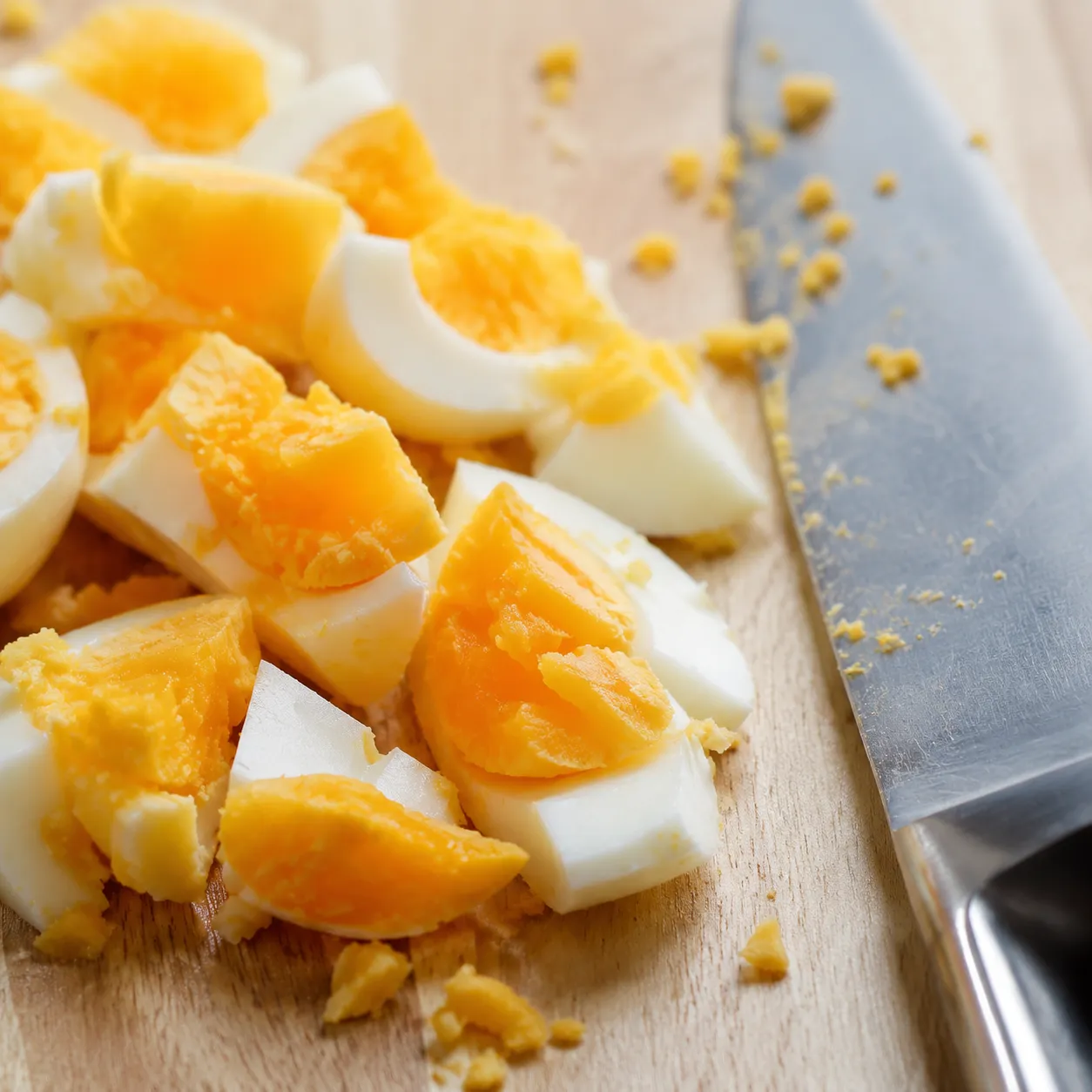 Chopped hard-boiled eggs on cutting board for egg salad recipe