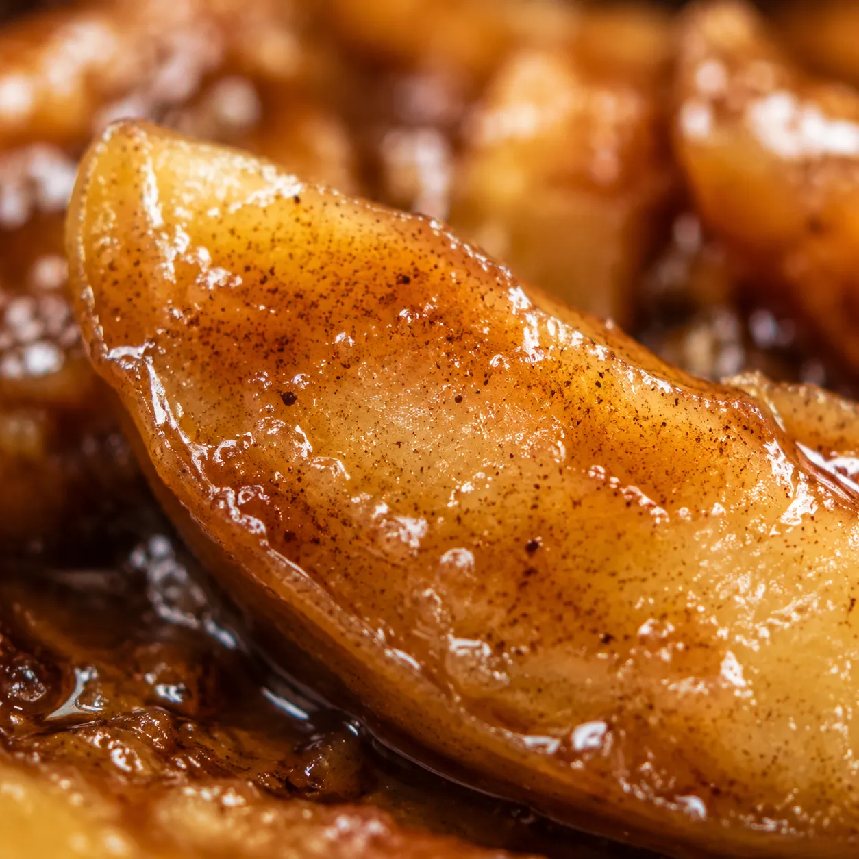 Close-up of glossy cinnamon-coated apple slice for apple pie filling
