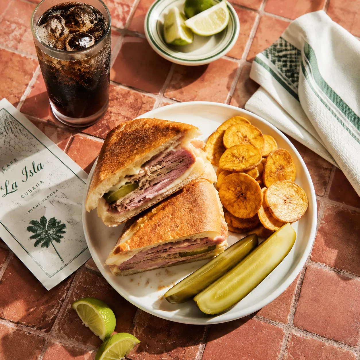 Cuban sandwich served with plantain chips and pickles