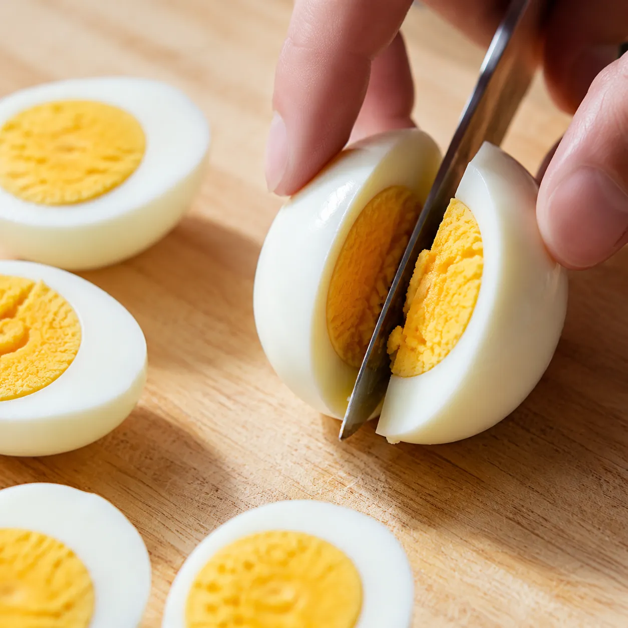 Slicing hard-boiled eggs in half for easy deviled eggs recipe