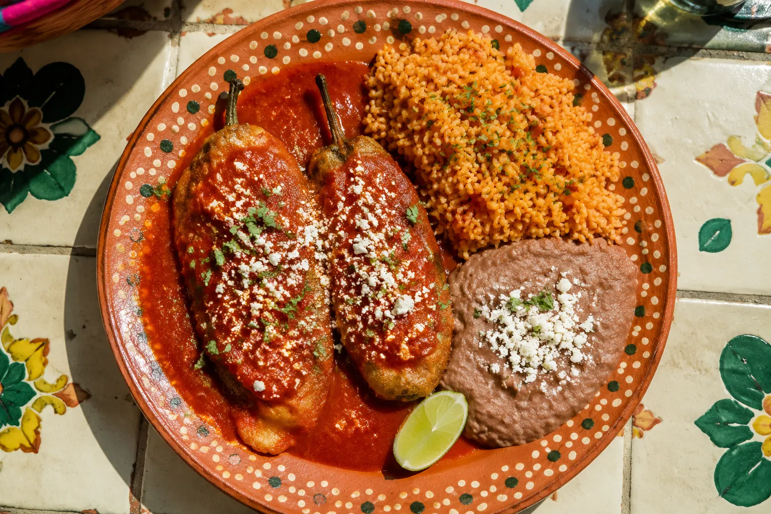 Chile relleno recipe plated with Mexican rice and refried beans