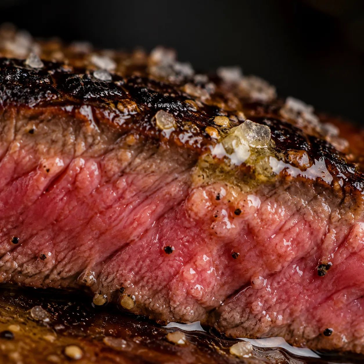 Close-up of medium-rare flat iron steak showing seared crust and pink interior