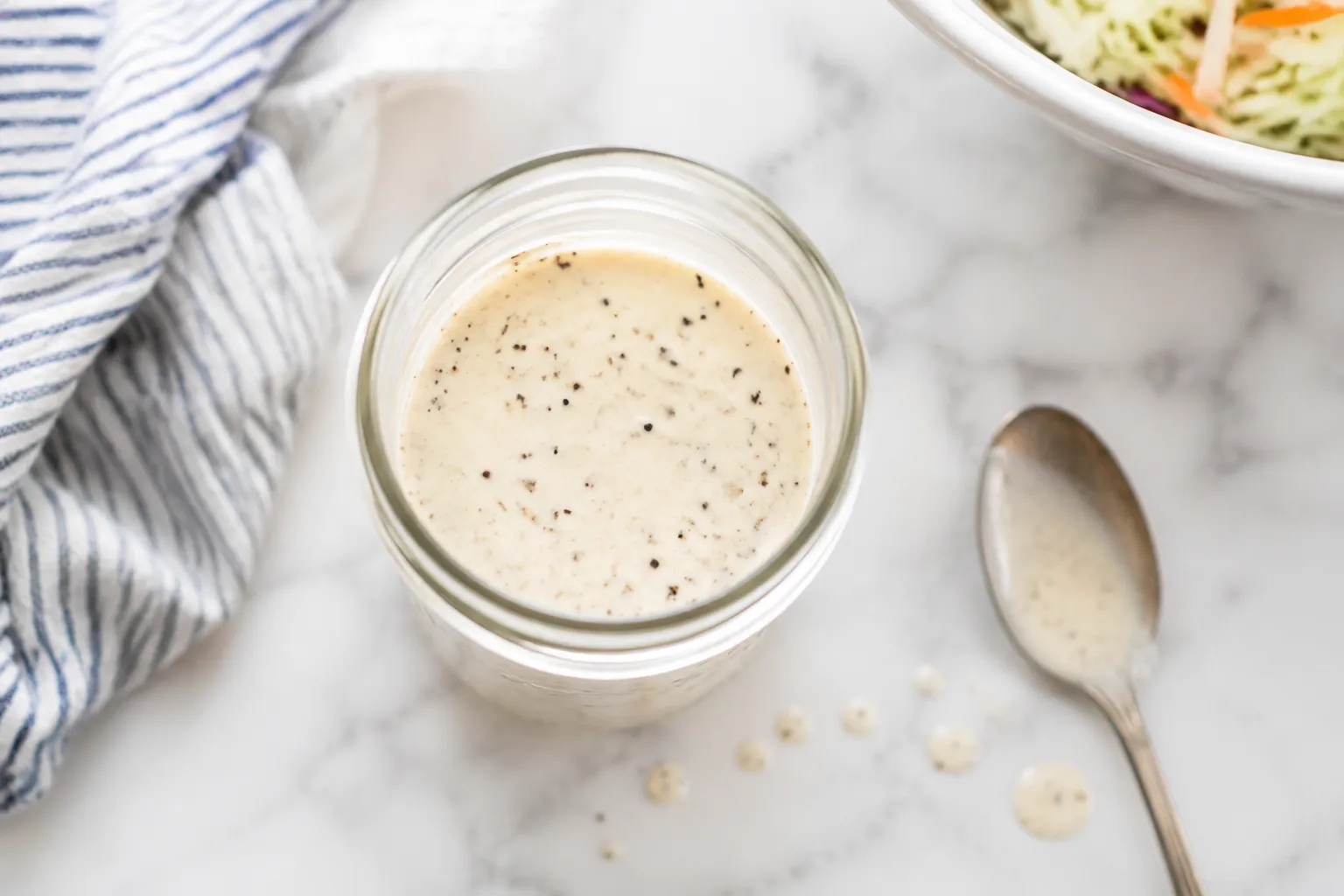 Homemade coleslaw dressing in a glass jar ready to use