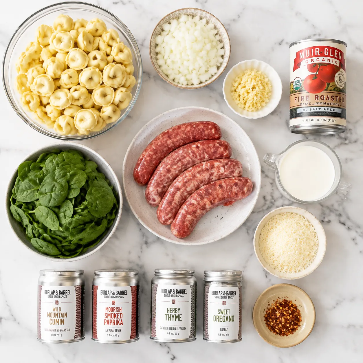 Tortellini soup ingredients flatlay with cheese tortellini, sausage, spinach, and cream