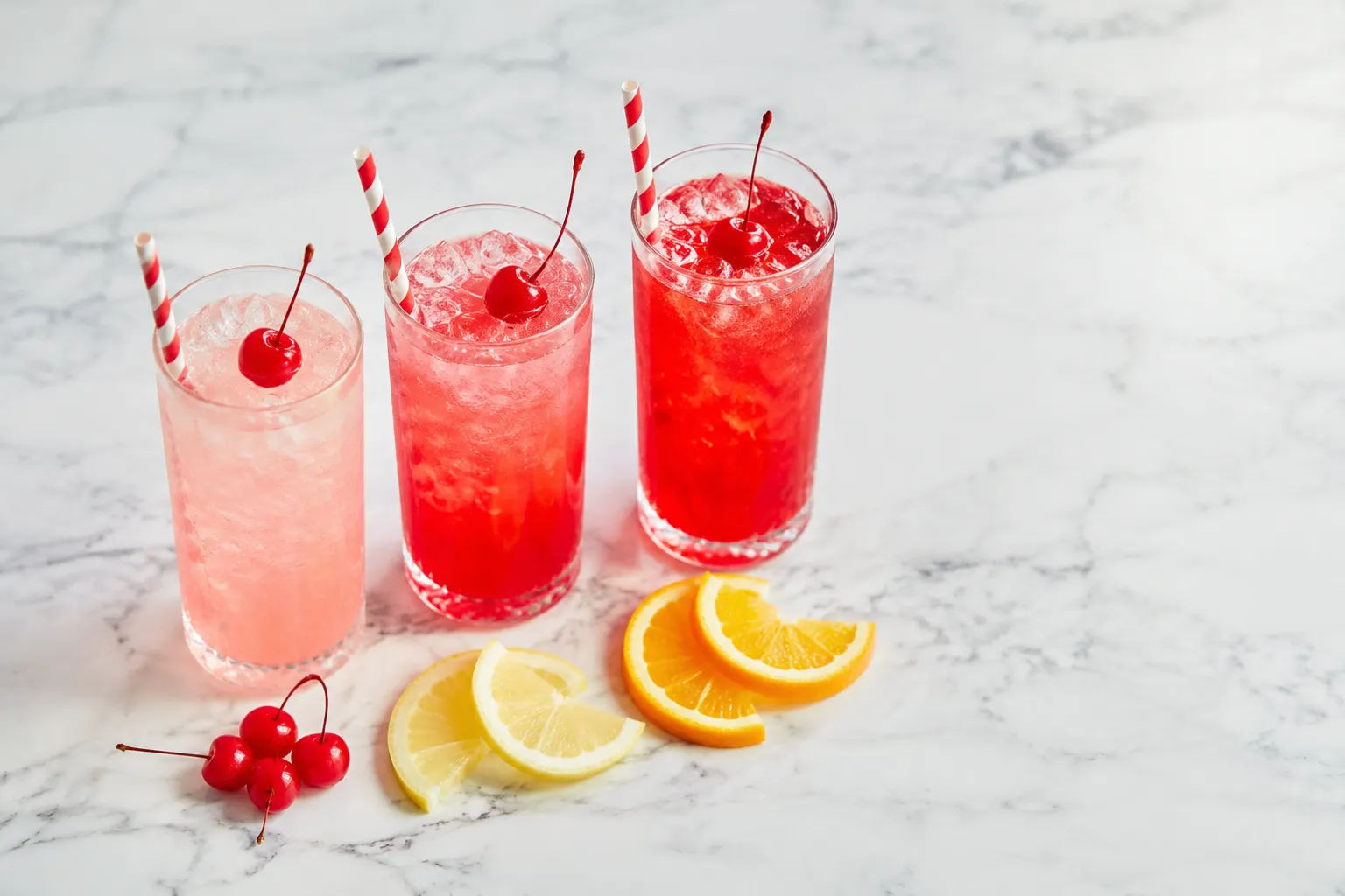 Three Shirley Temple drinks showing different grenadine gradient effects
