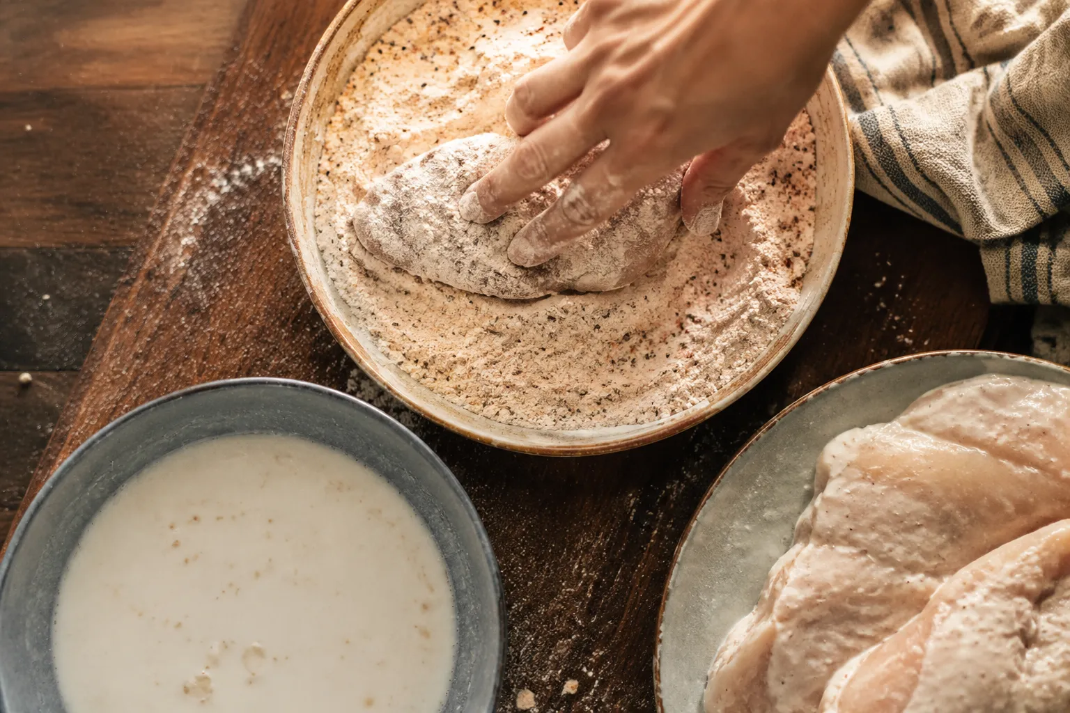 Dredging chicken in seasoned flour for crispy fried chicken recipe