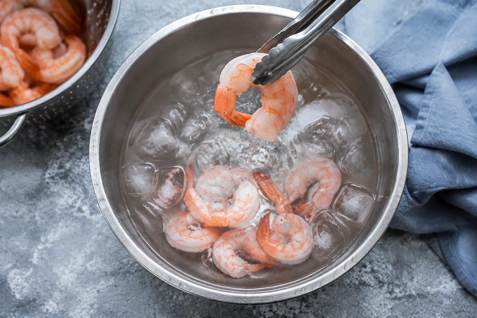 Shocking poached shrimp in an ice bath for tender shrimp cocktail