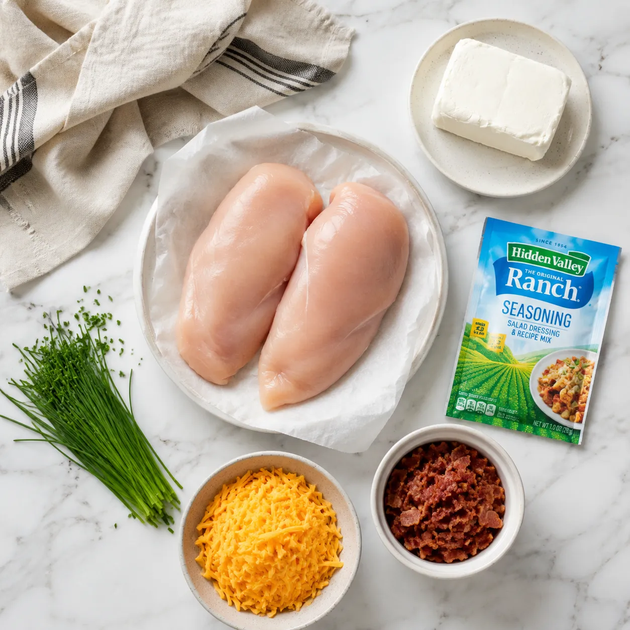 Crack chicken recipe ingredients flatlay with cream cheese, ranch, bacon, and cheddar