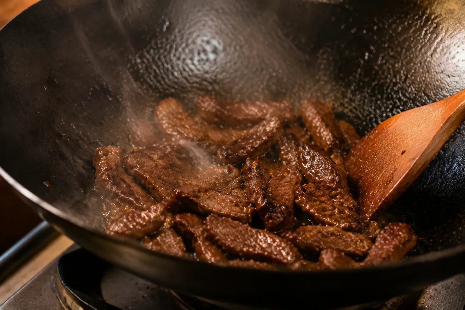 Searing flank steak strips in a wok for tender beef stir fry