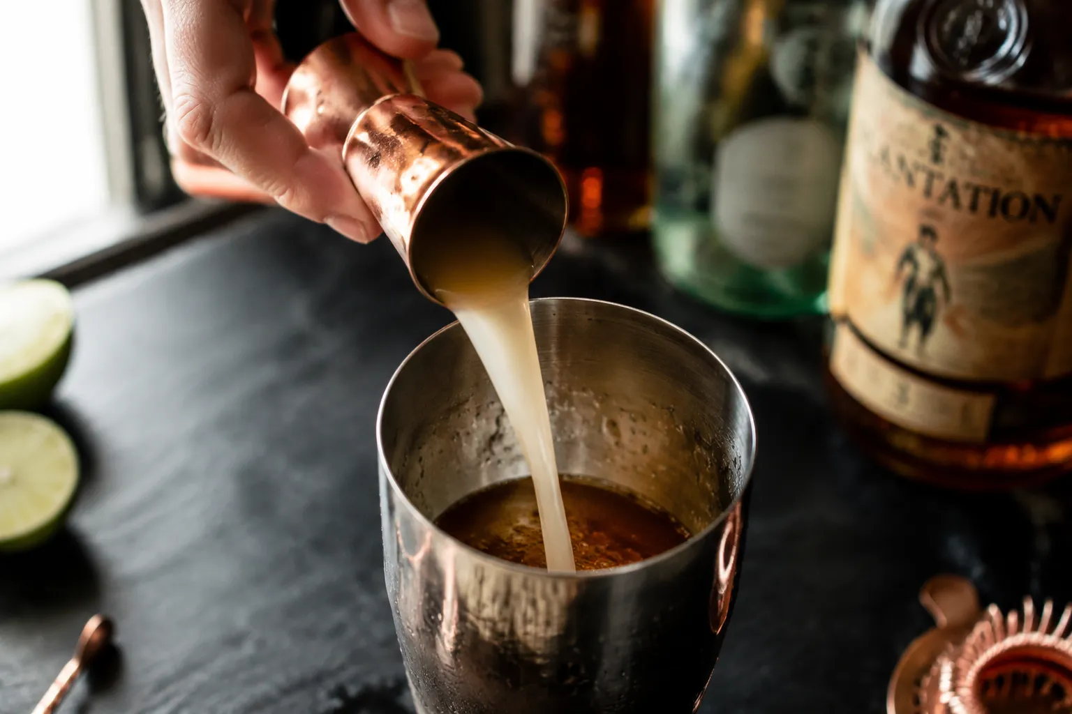 Pouring orgeat syrup into a mai tai cocktail shaker