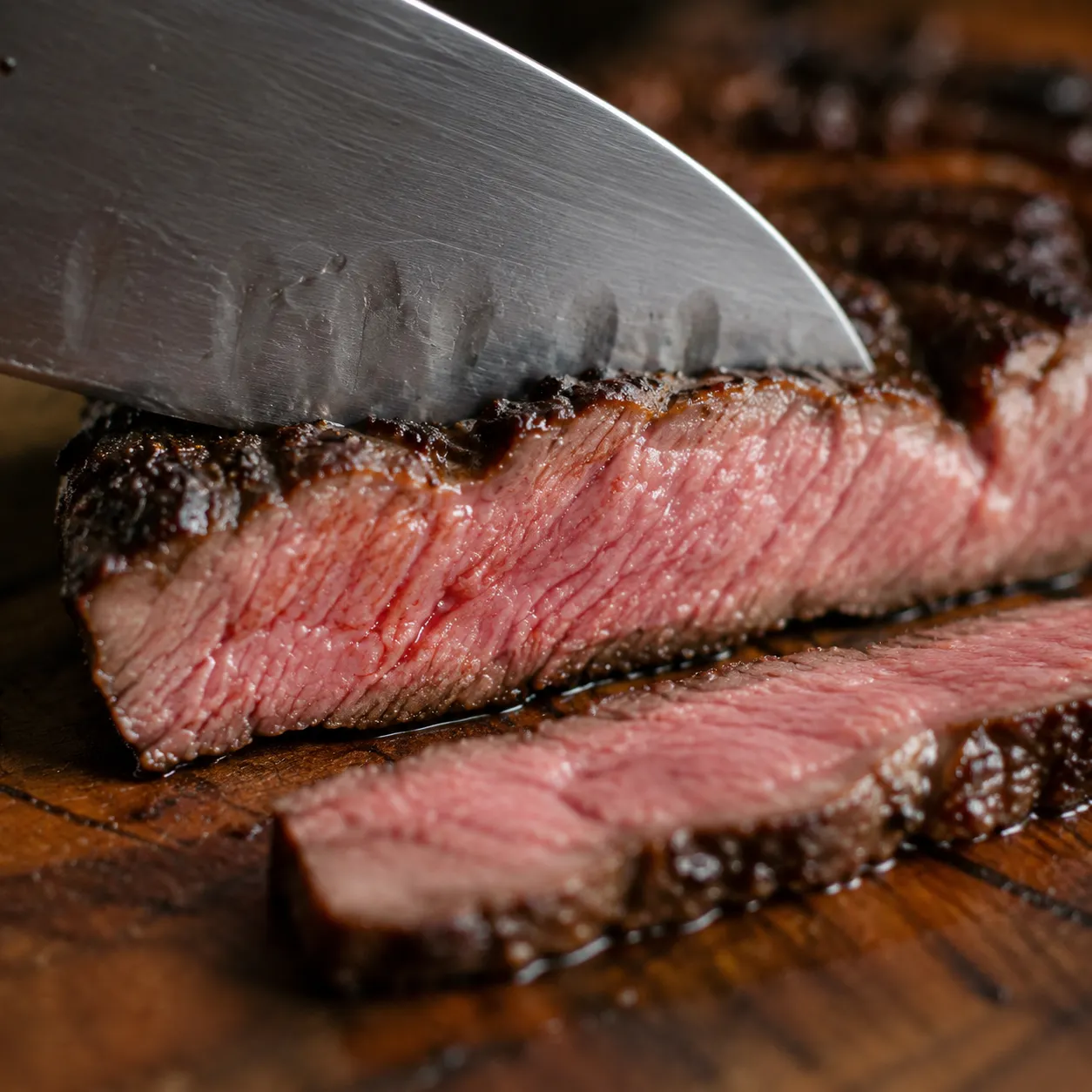 Slicing grilled skirt steak against the grain showing juicy pink interior