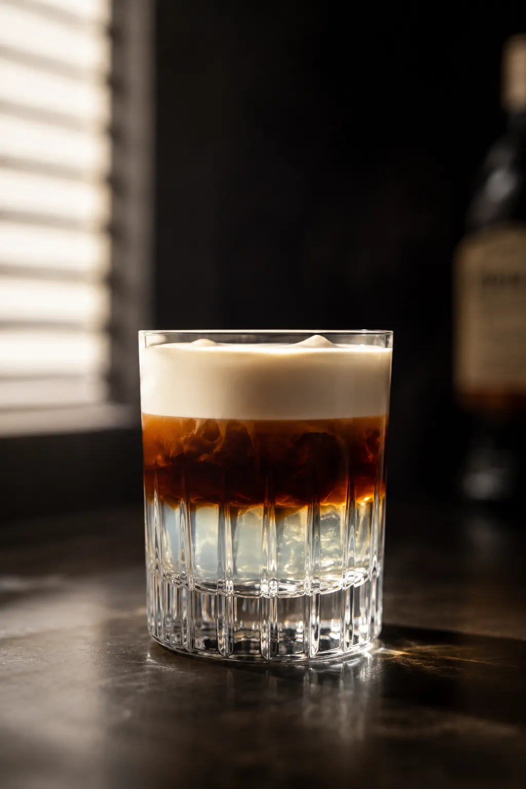 Layered White Russian drink showing cream floating over coffee liqueur