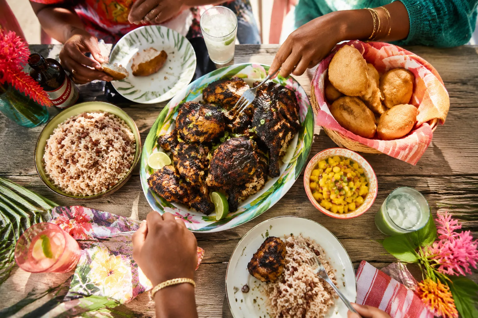 Family-style jerk chicken dinner spread with Caribbean sides