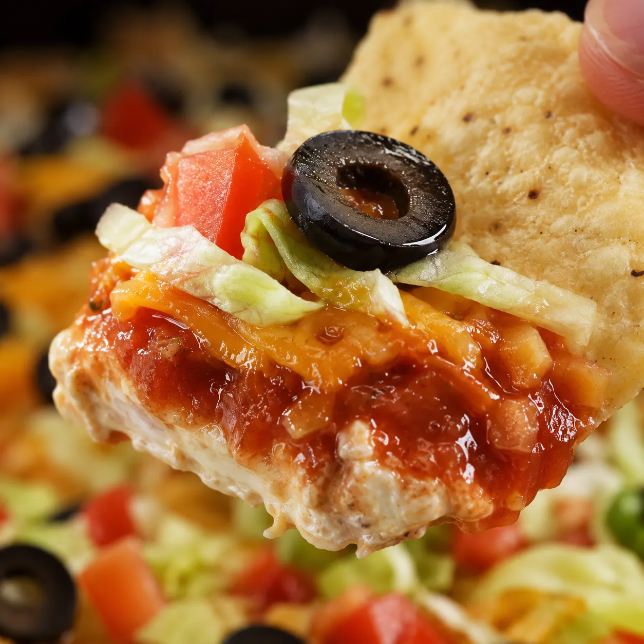 Close-up of taco dip layers on a tortilla chip