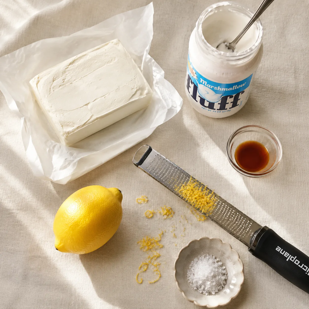 Fruit dip recipe ingredients flatlay with cream cheese, marshmallow fluff, vanilla, and lemon zest