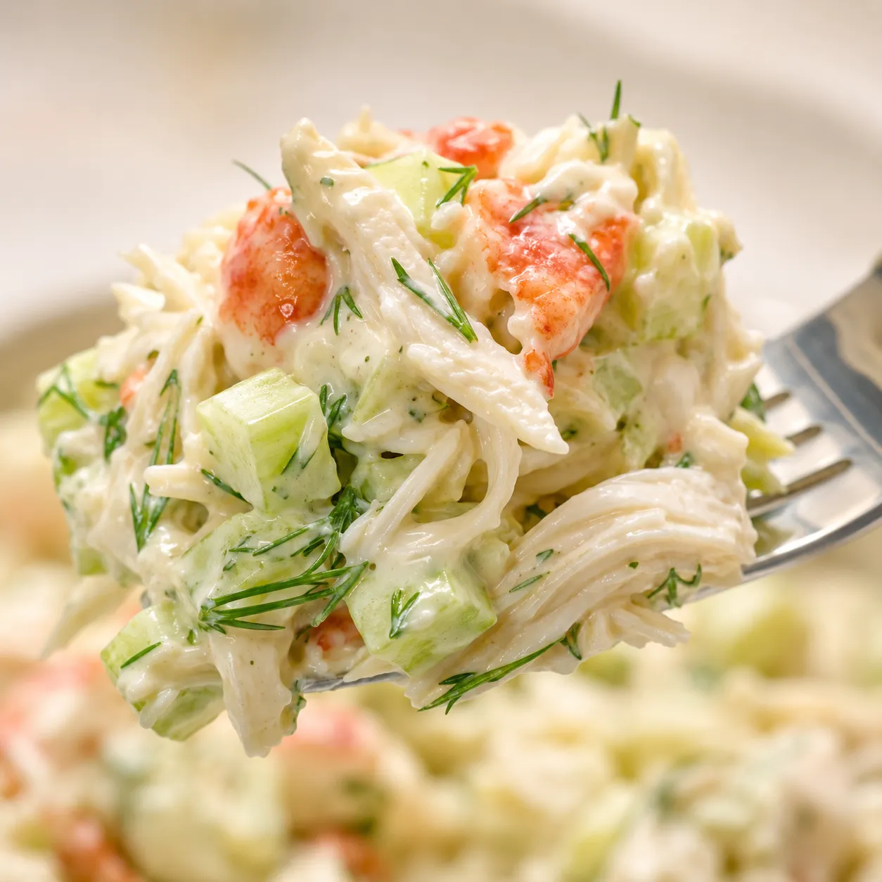 Close-up forkful of creamy crab salad showing tender crab and fresh dill