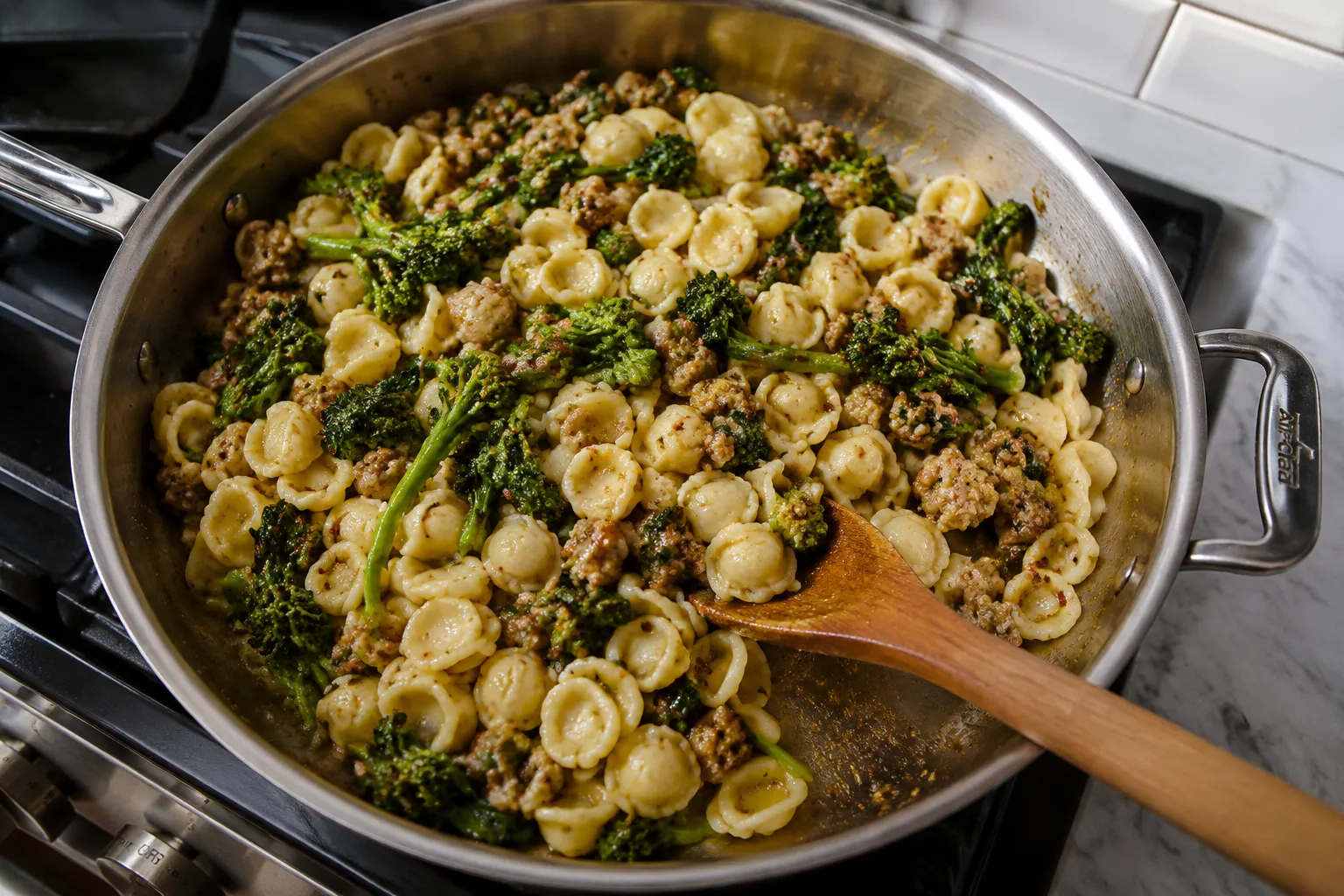 Tossing orecchiette pasta with sausage and broccoli rabe in a skillet