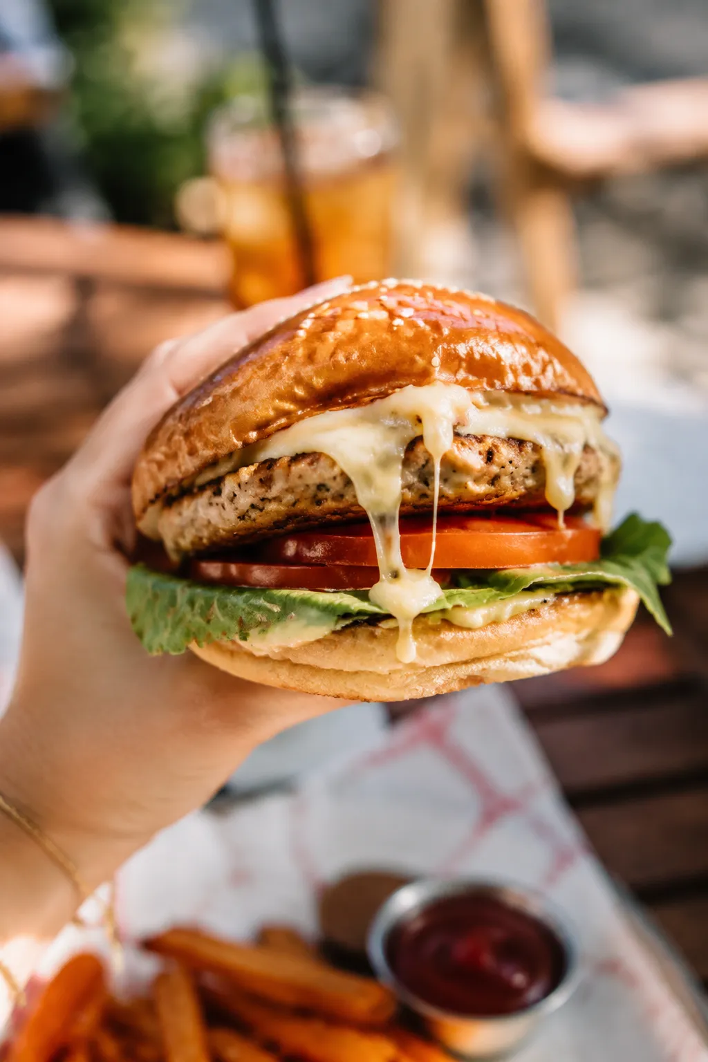 Hand holding up a juicy turkey burger ready to eat