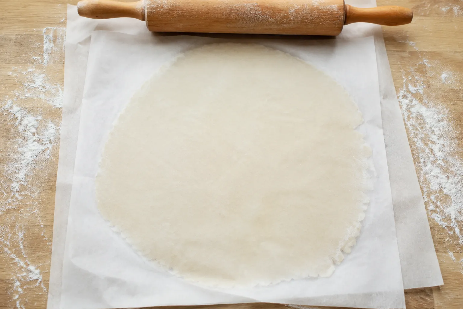Rolling gluten free cracker dough thin between parchment sheets