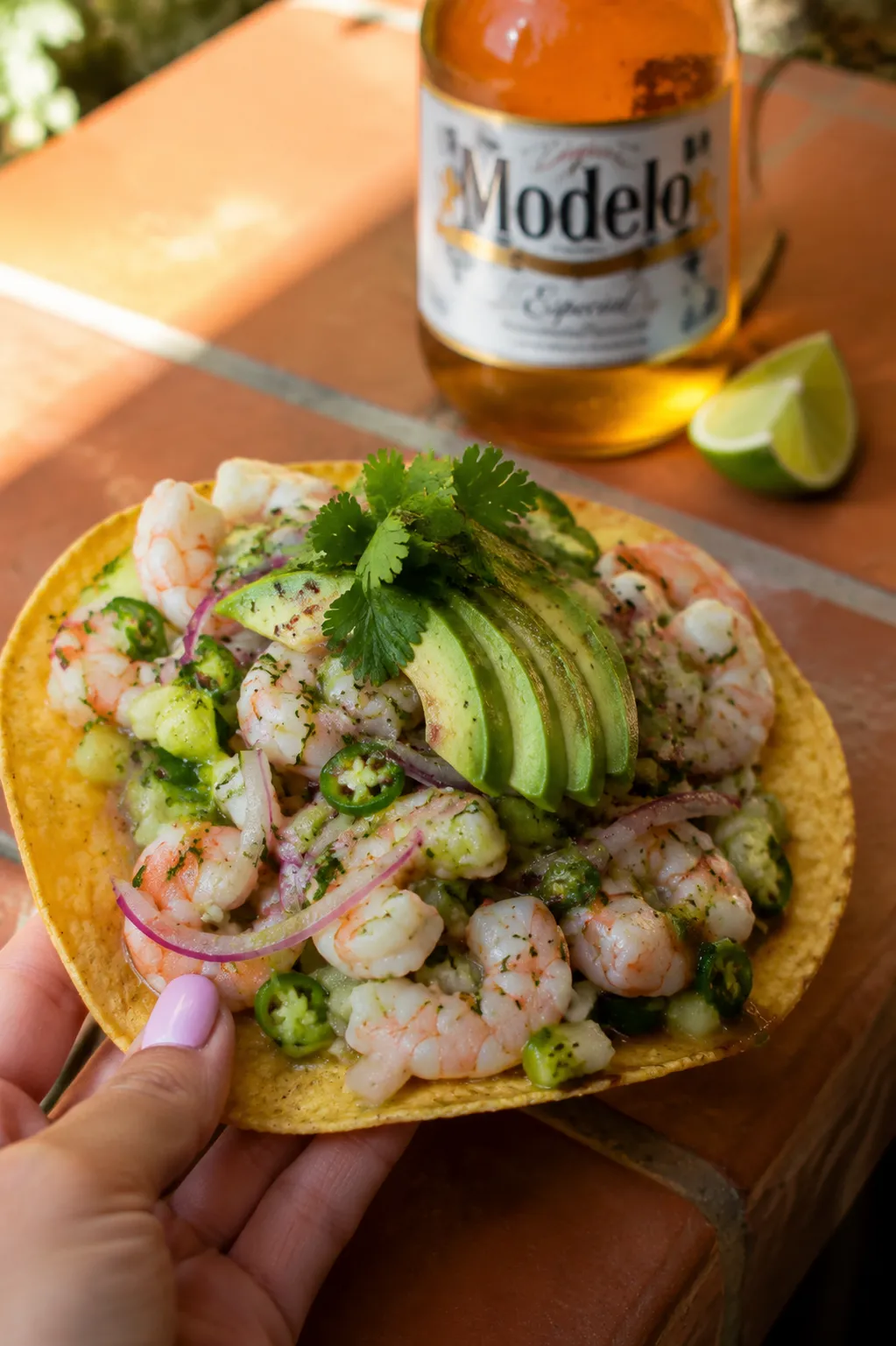 Aguachile tostada held up with avocado and cucumber, summer serving