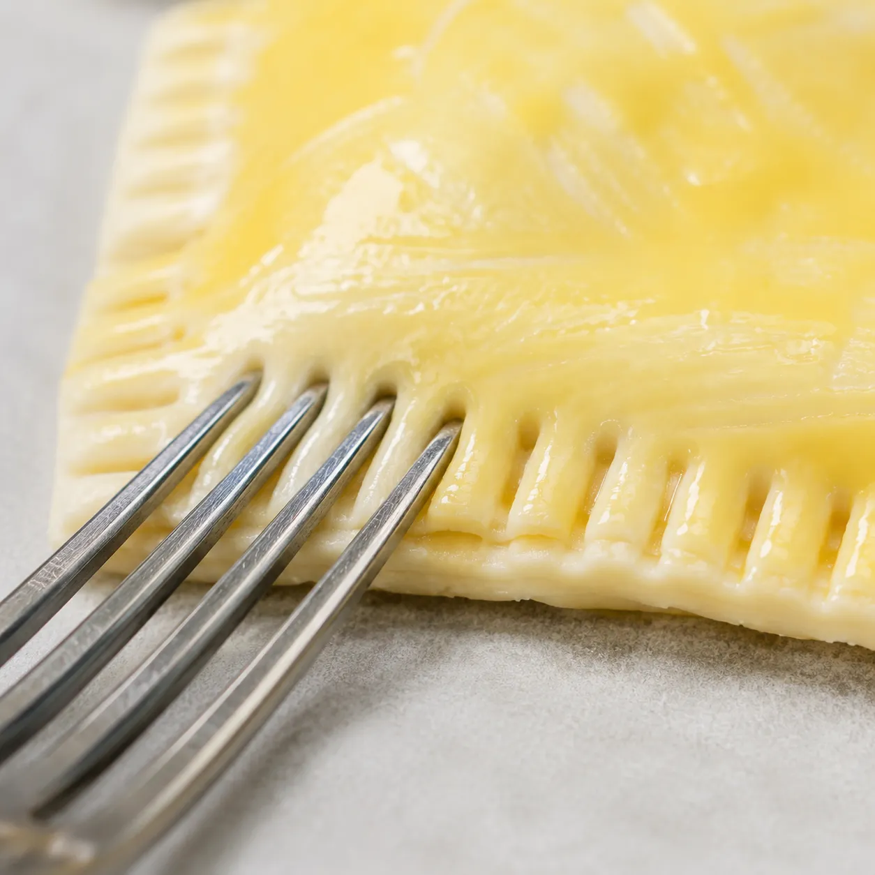 Crimping the edges of toaster strudel pastries with a fork