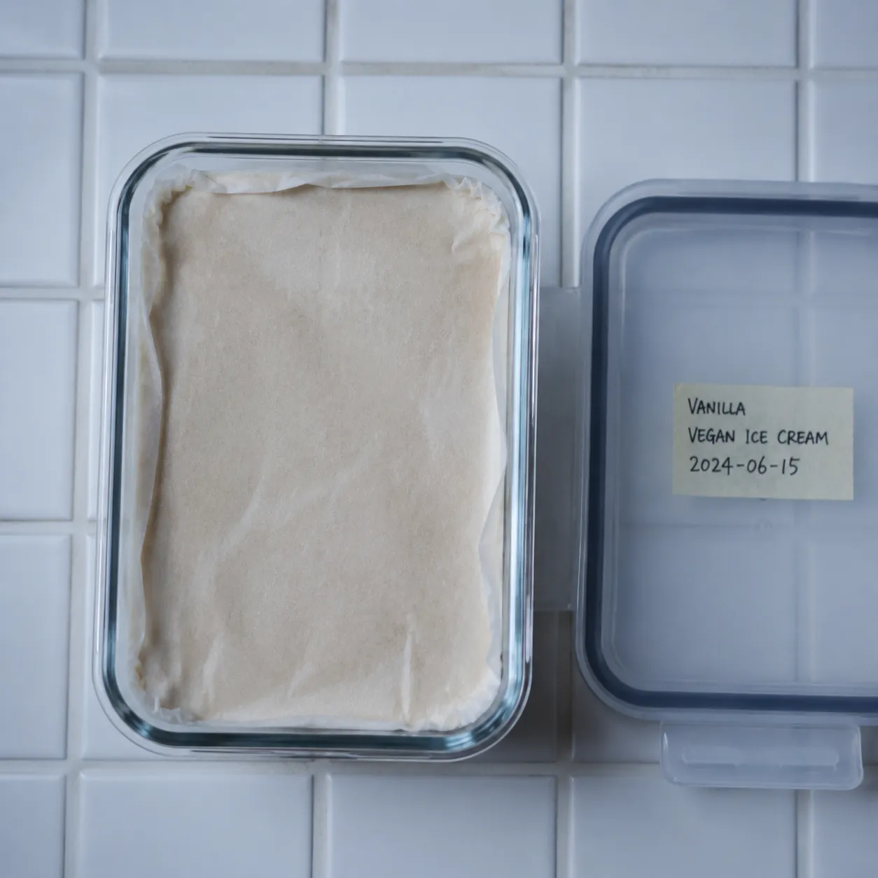 Storing homemade vegan ice cream in a glass container with parchment