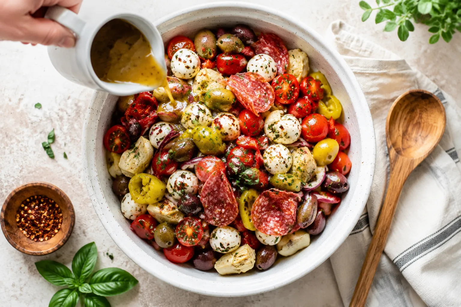 Tossing antipasto salad with homemade Italian vinaigrette