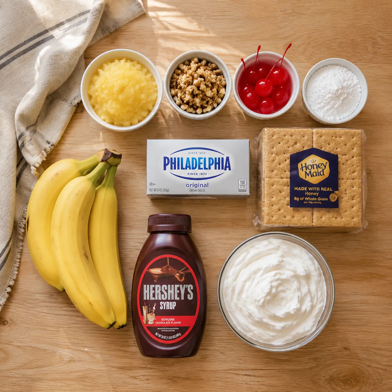 Ingredients for banana split banana cake laid out overhead on a wood board