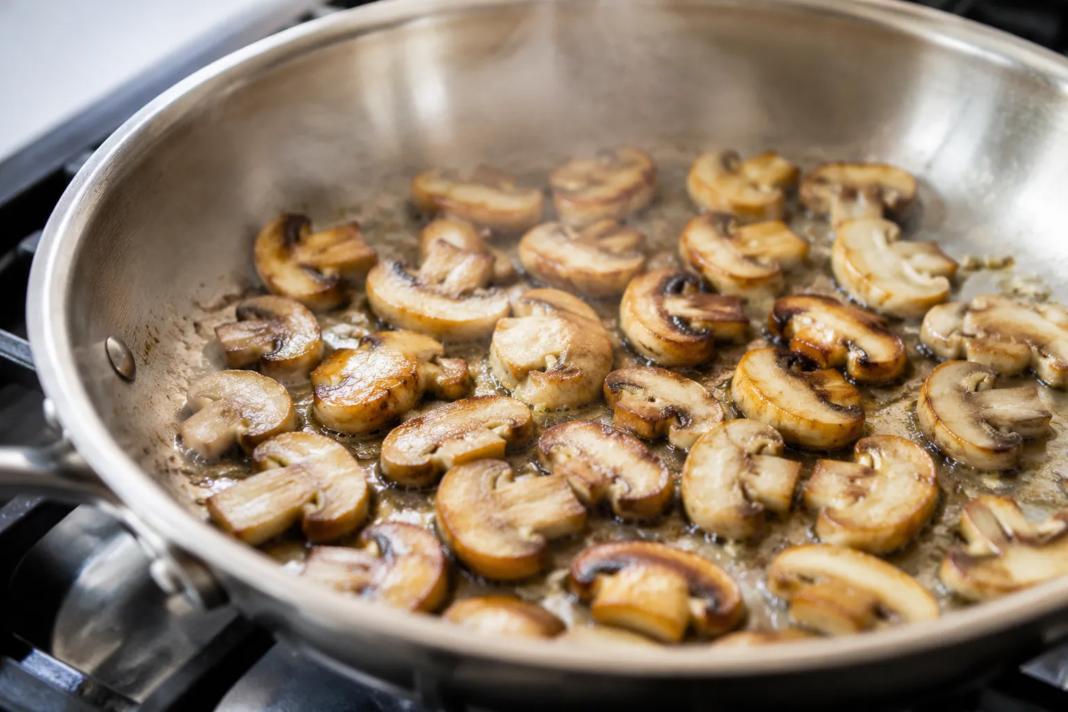 Mushrooms searing in a single layer in a hot skillet