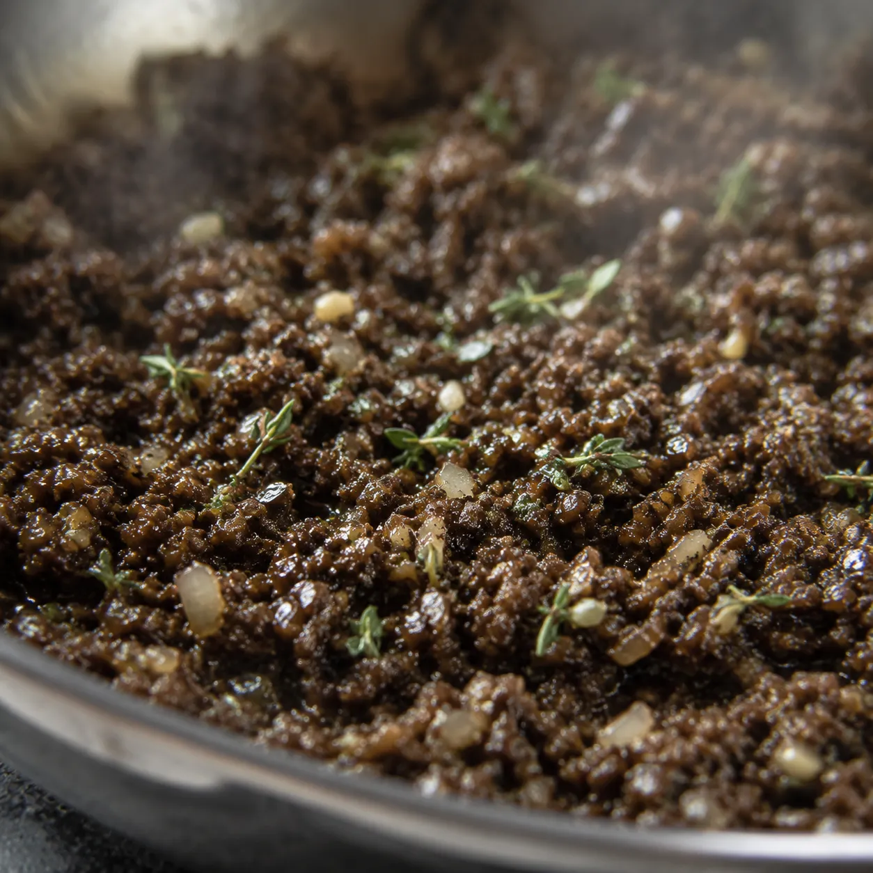 Mushroom duxelles cooking down for classic beef wellington recipe