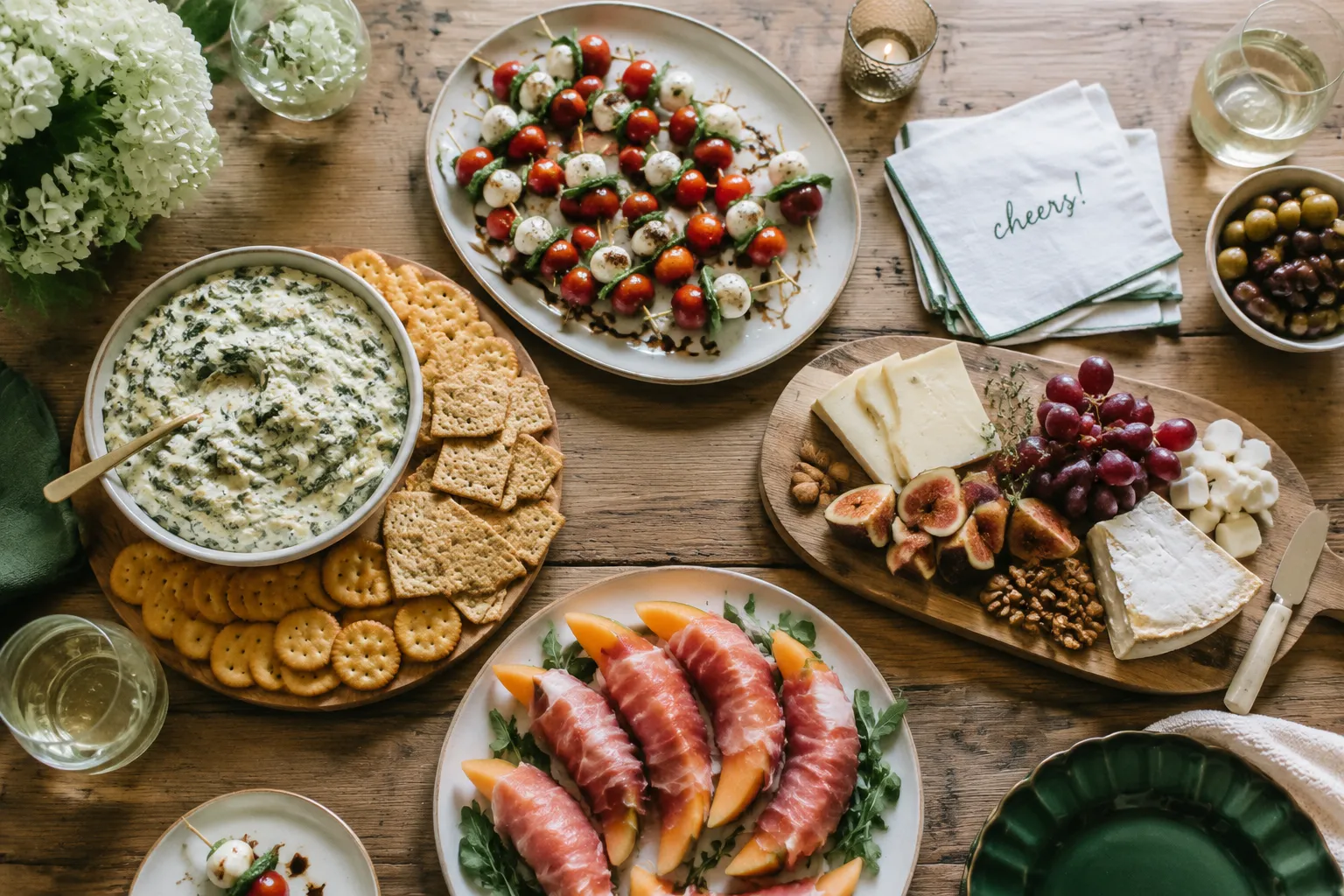 Easy appetizers spread on a wooden party table with dips and skewers