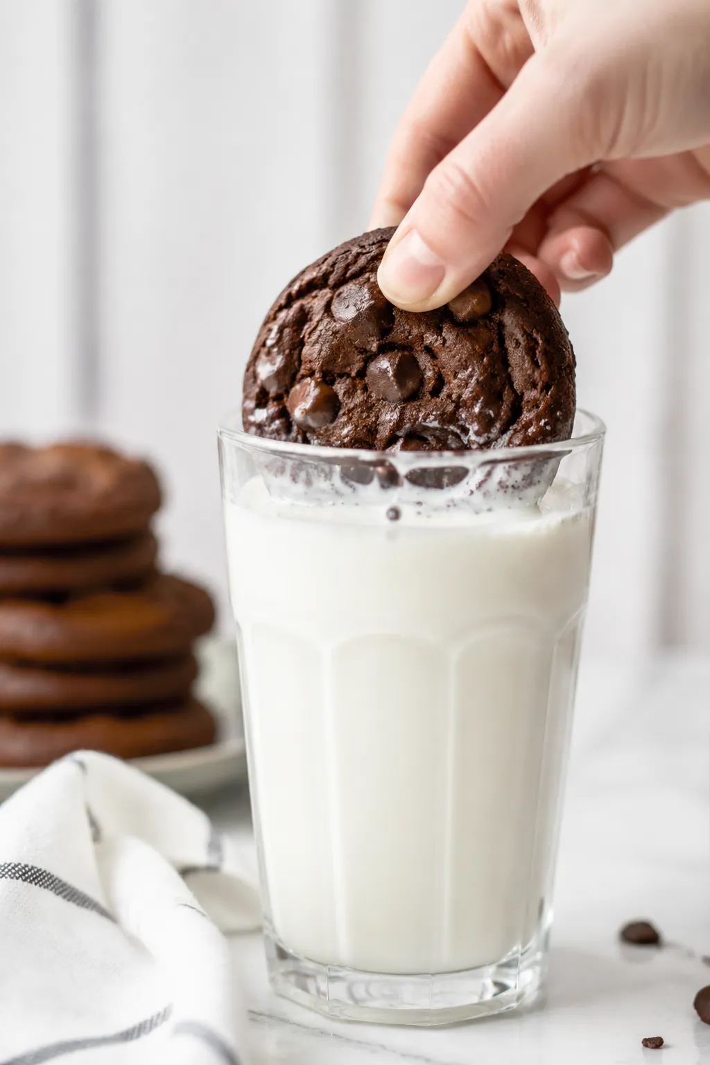 Dunking a double chocolate chip cookie into a glass of milk