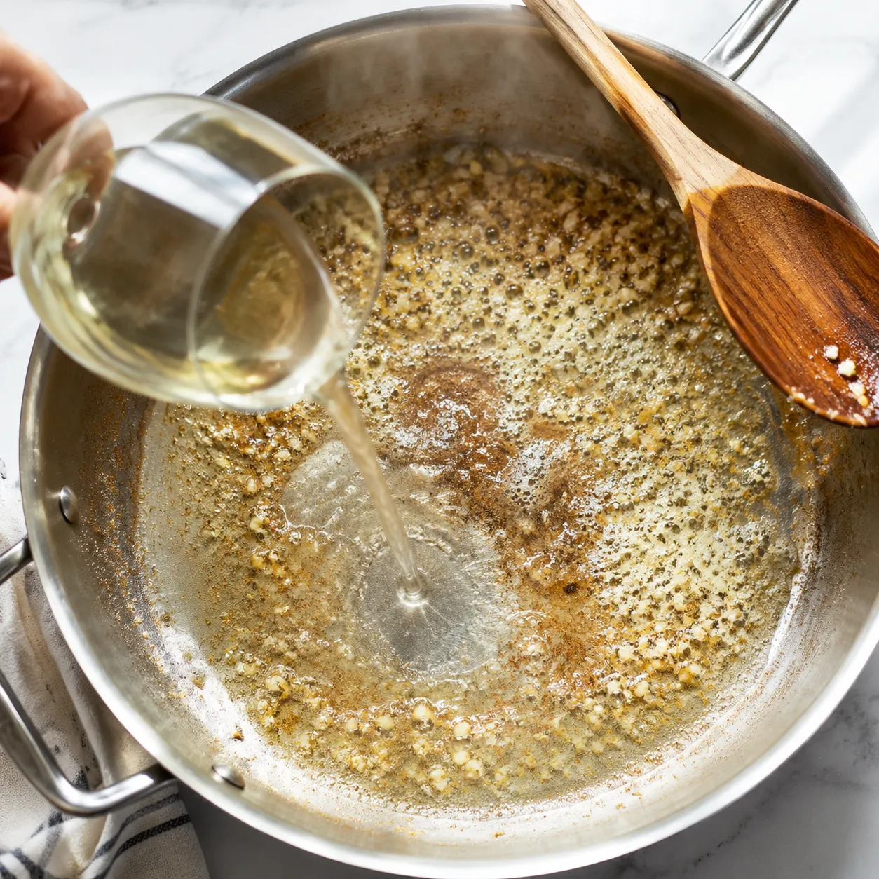 Building creamy garlic white wine sauce for chicken Florentine.