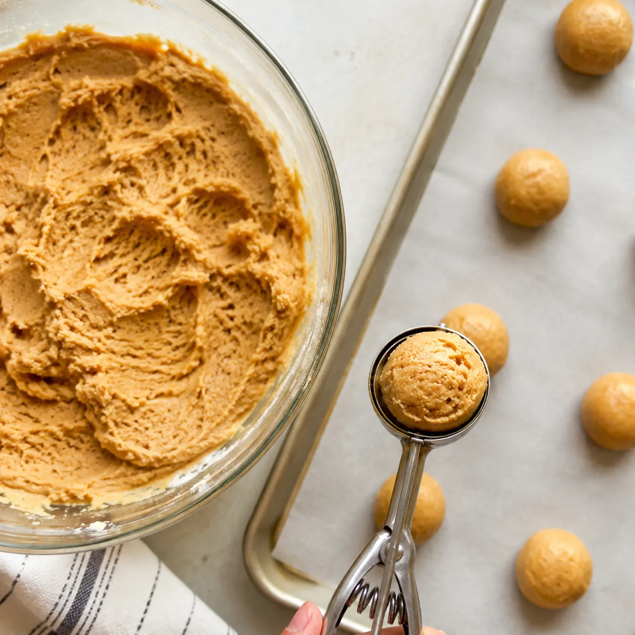 Scooping peanut butter cookie dough onto baking sheet