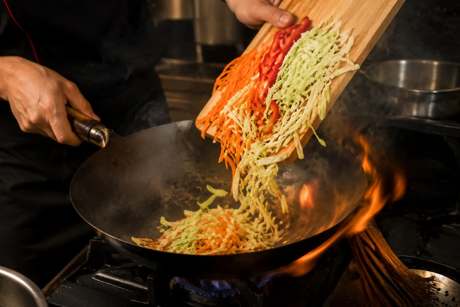 Stir-frying vegetables in a hot wok for mei fun rice noodle stir fry