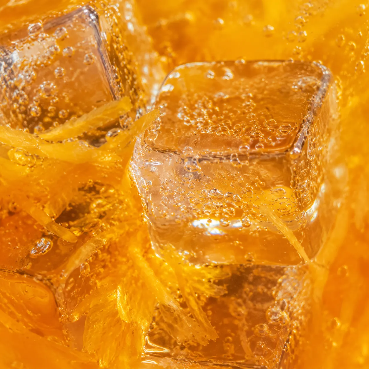 Macro close-up of a screwdriver drink with ice and orange pulp
