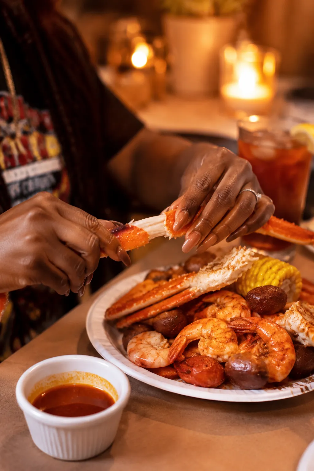 Cracking crab legs at a seafood boil dinner with Cajun butter dipping sauce