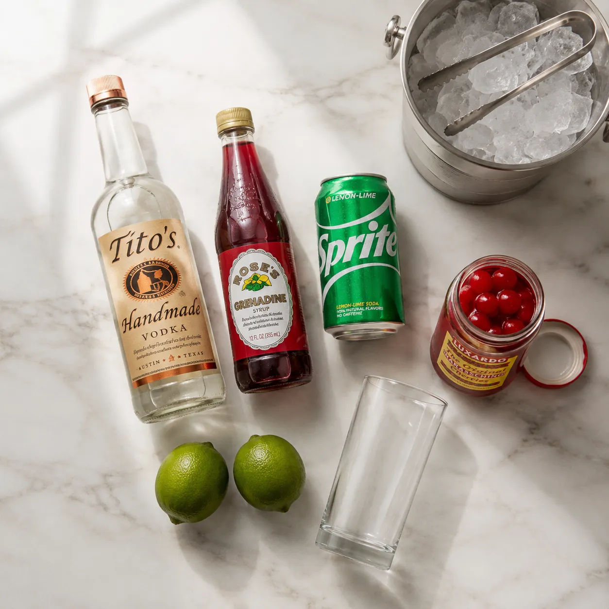 Dirty Shirley ingredients flatlay with vodka, grenadine, soda, and cherries