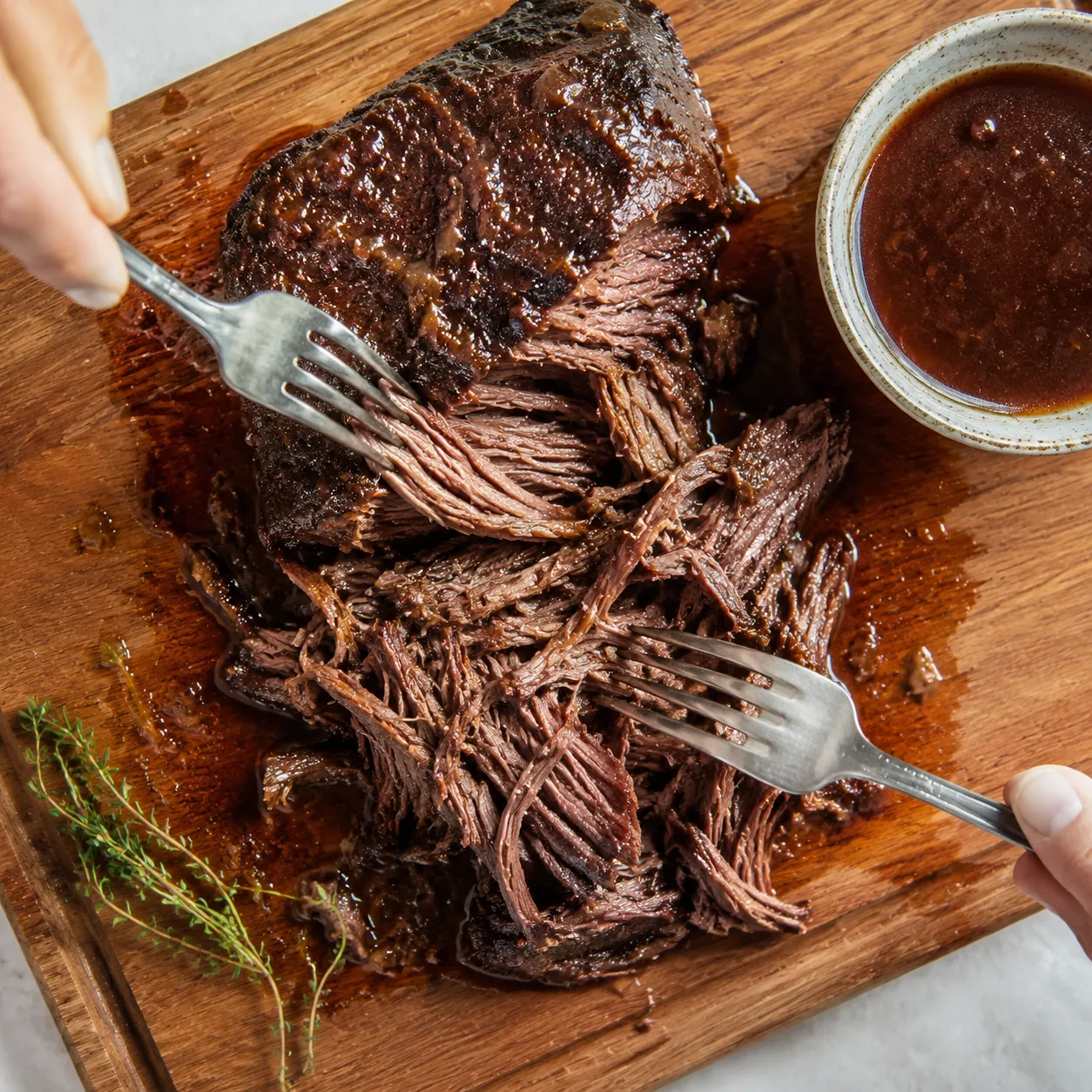 Shredding tender braised beef for machaca with two forks