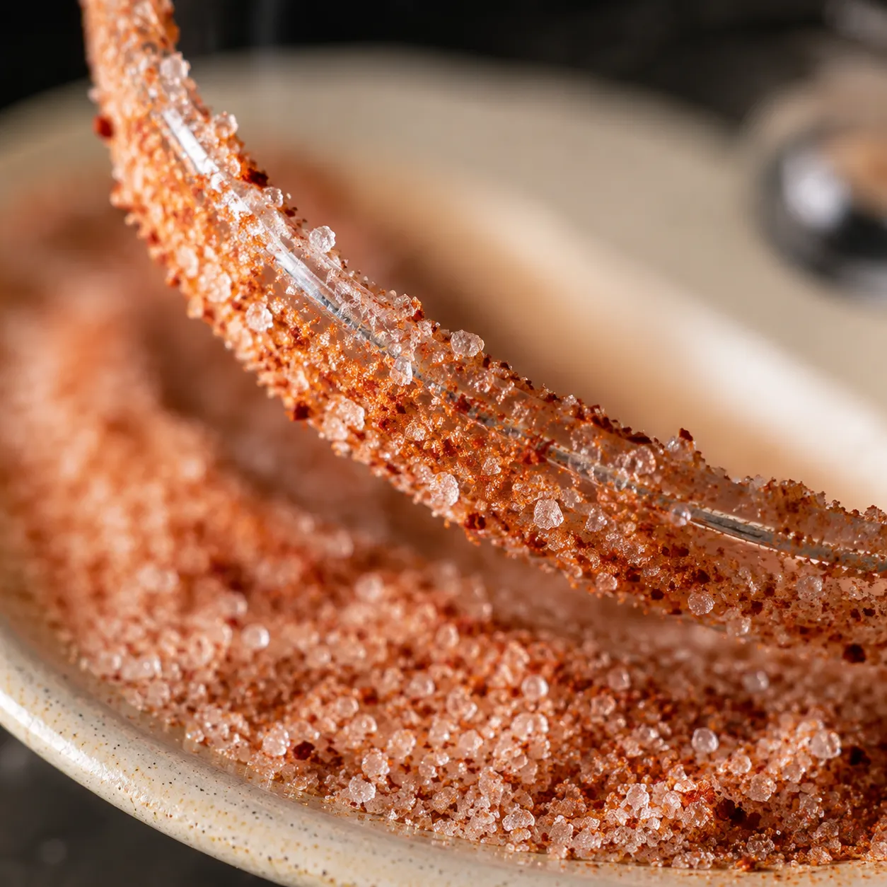 Rimming a margarita glass with flaky salt and Tajín for watermelon margaritas