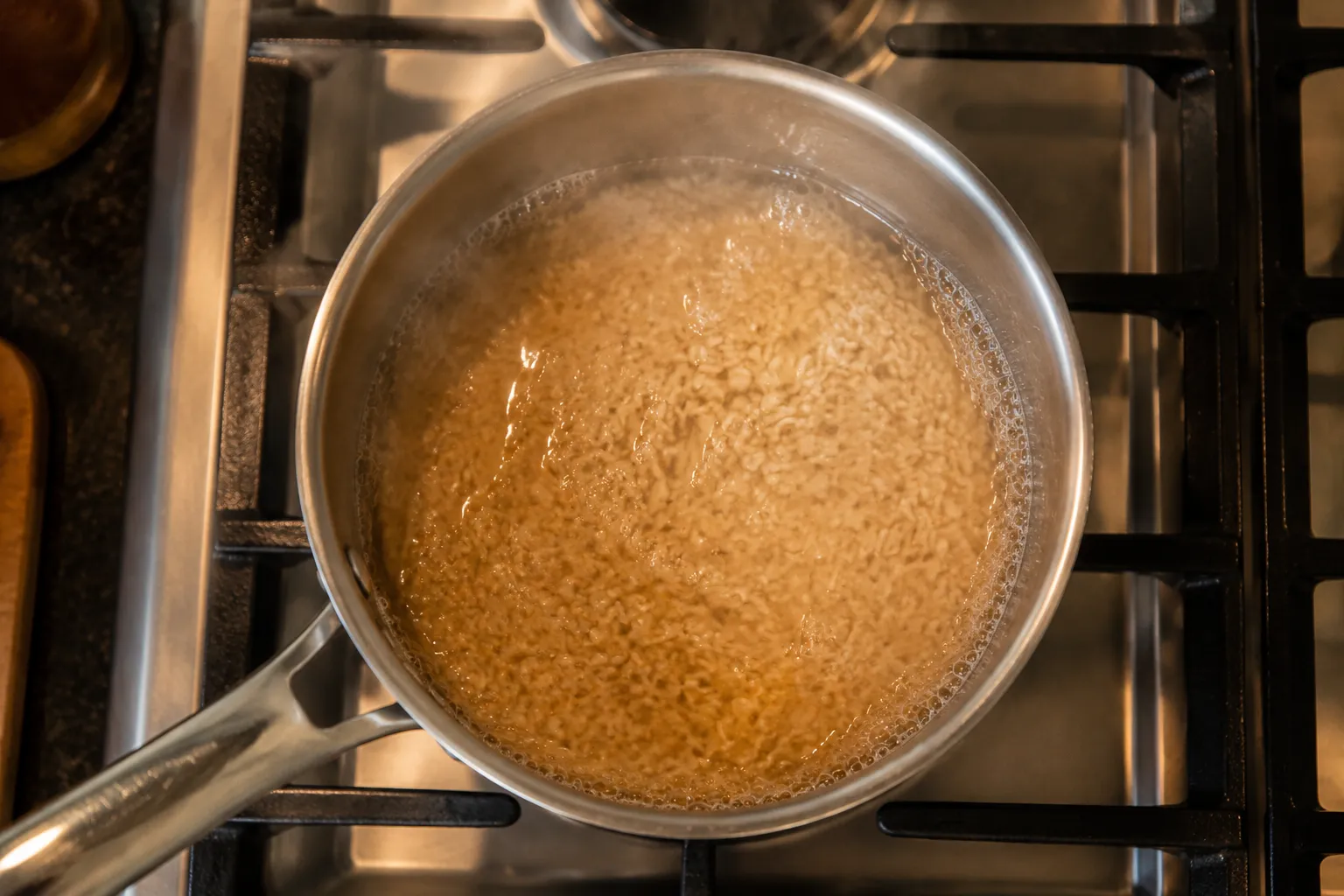 Brown rice simmering in saucepan on stovetop