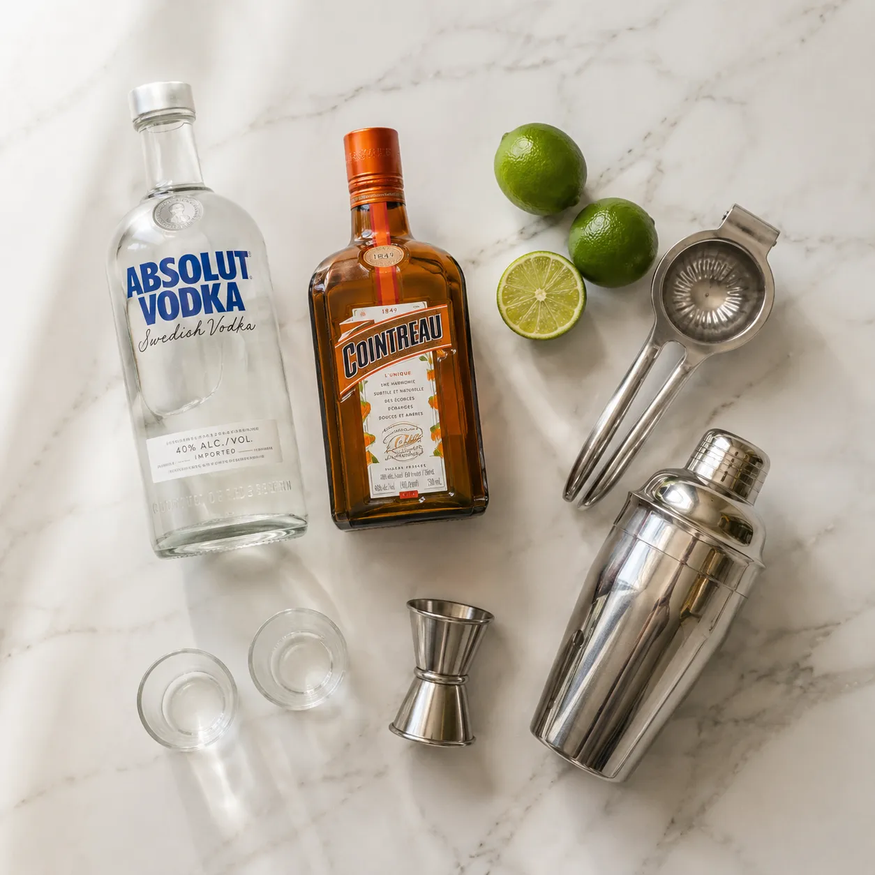 Kamikaze shot cocktail ingredients flatlay with vodka, triple sec, and fresh limes