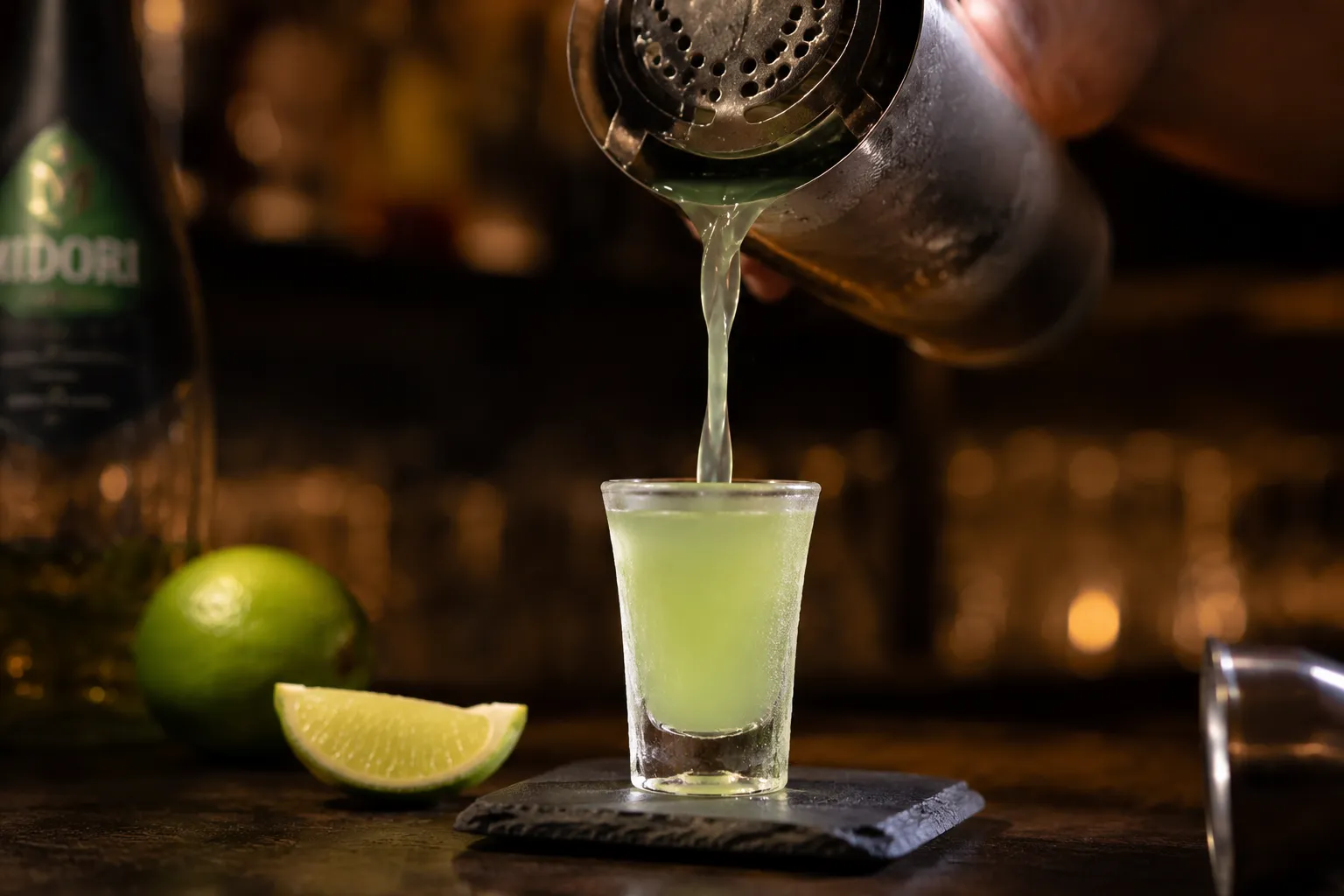 Straining kamikaze shot cocktail into chilled shot glass