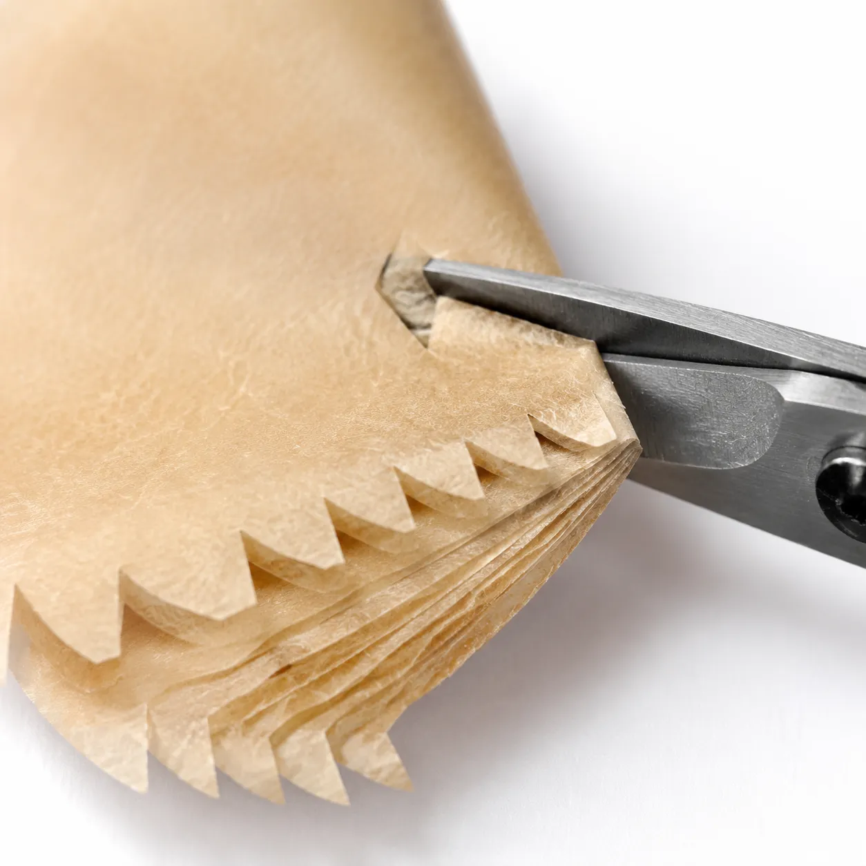 Cutting holes into parchment paper to make a perforated air fryer liner