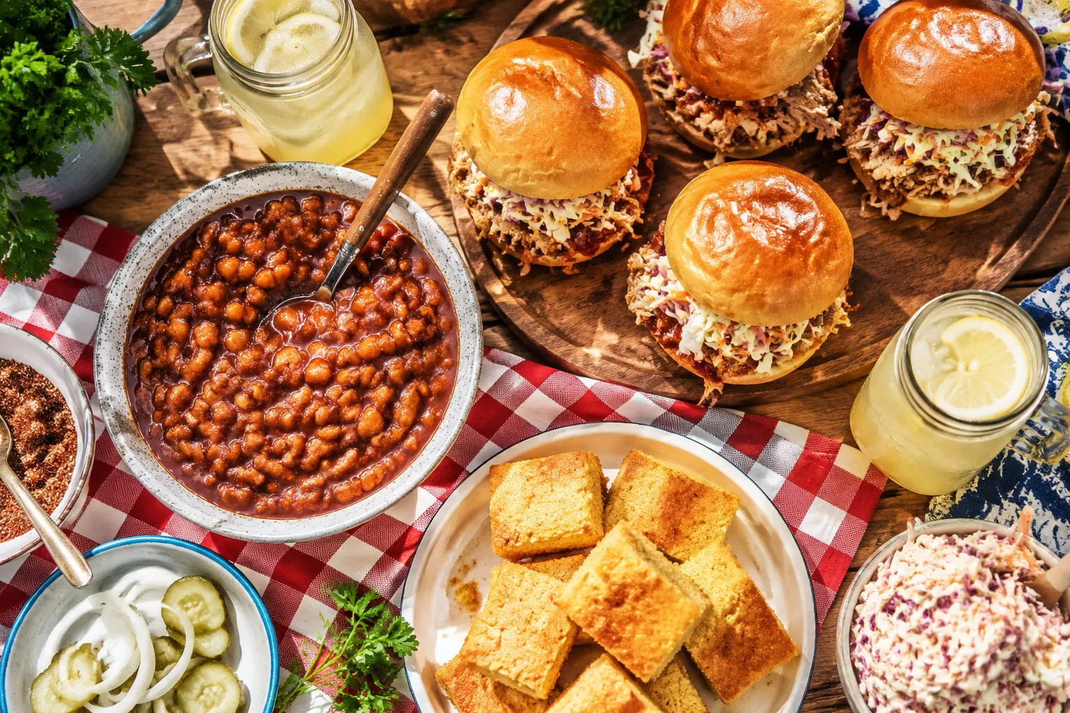 Baked beans served at a backyard BBQ with pulled pork sandwiches and coleslaw