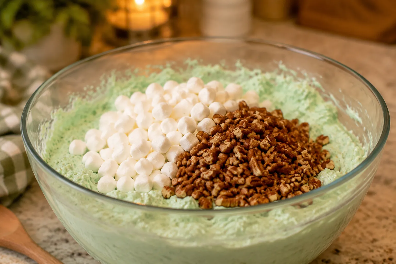 Adding mini marshmallows and chopped pecans to the fluff salad