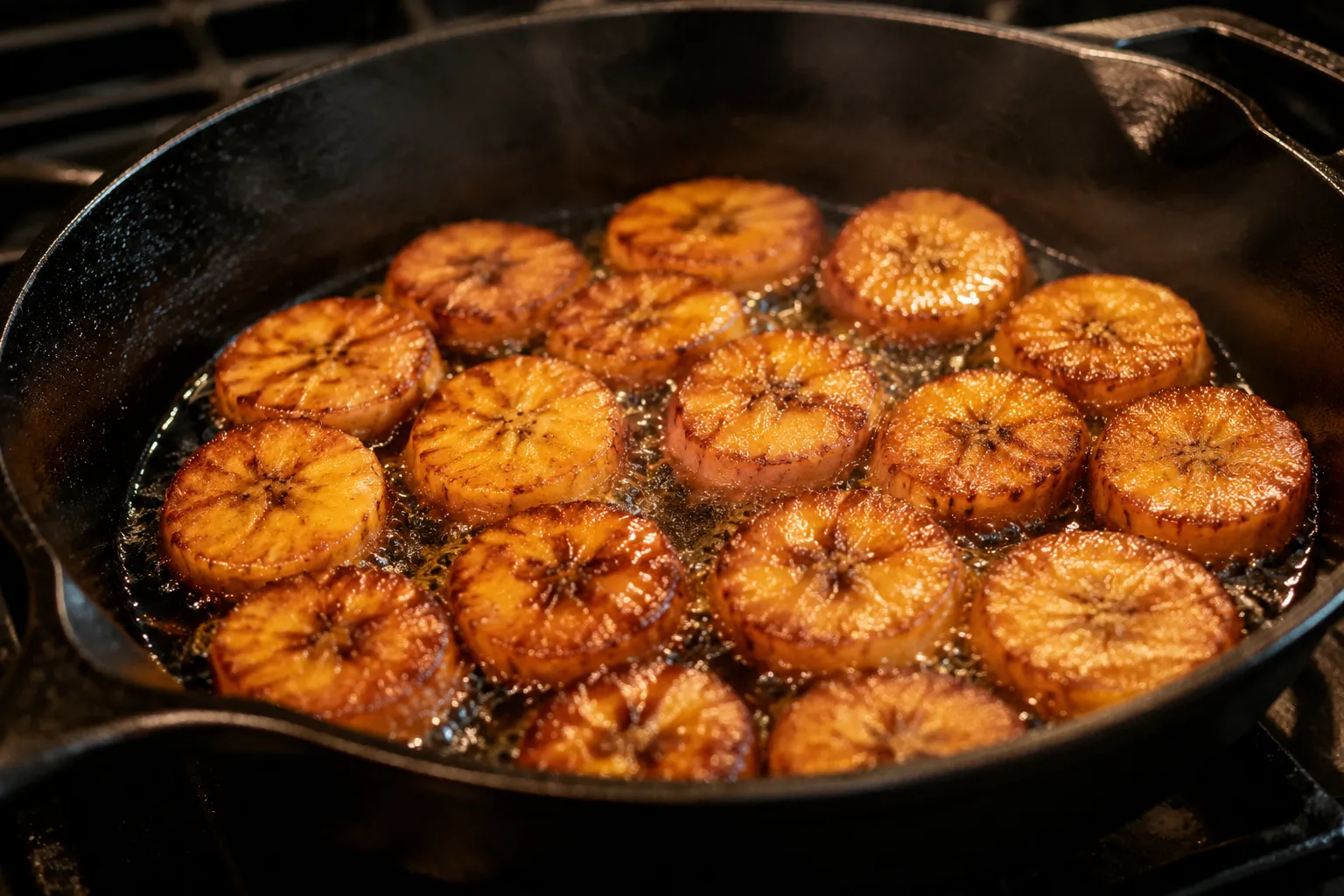 Plantain slices frying in a cast iron skillet until golden brown