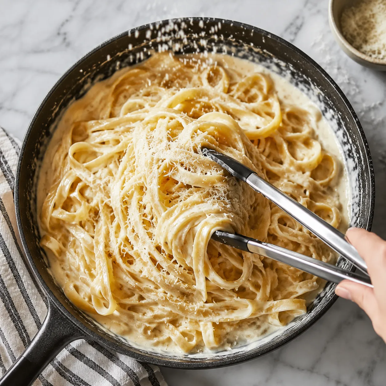 Tossing pasta in creamy parmesan sauce for a quick weeknight pasta supper